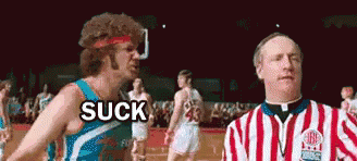 a referee is standing next to a basketball player who is saying suck .