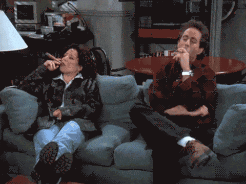 1436539971-elaine-benes-and-jerry-seinfeld-sitting-on-couch-smoking-cigars.gif