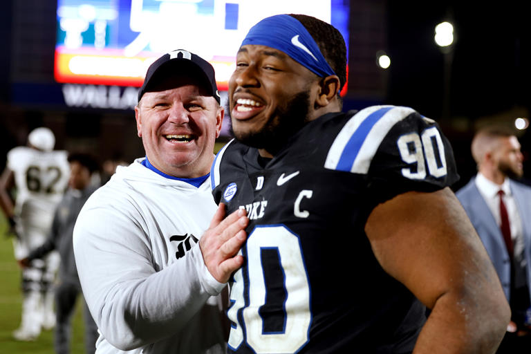 Head coach Mike Elko of the Duke Blue Devils celebrates with DeWayne Carter #90 following their 24-21 victory against the Wake Forest Demon Deacons at Wade Stadium on Nov. 2, 2023, in Durham, North Carolina.