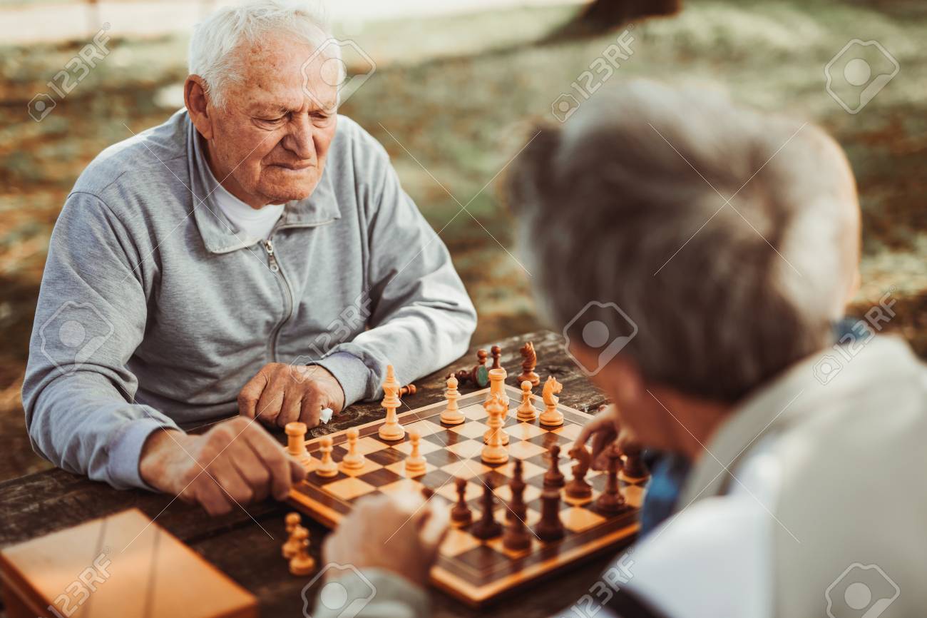 91913727-active-retired-people-old-friends-and-free-time-two-senior-men-having-fun-and-playing-chess-at-park-.jpg